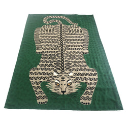 Bengal Tiger Carpet Emerald Green. Each carpet is made by hand by skilled artisans in Kashmir, the most northern part of India. They use a technique called chainstitch where colourful pure wool yarn is being stitched by a hook through thick cotton. Each carpet takes up to two months to complete.   We are stocking these beautiful carpets in a selection of bold colours in very small quantities. This one is a light beige and black tiger on a bold emerald green background. 